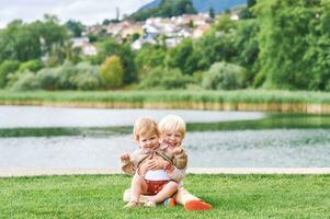 draussen Porträt von bezaubernd glücklich Kinder spielen zusammen Nächster zu See oder Fluss, Geschwister Liebe foto