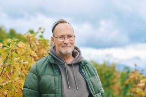 draussen Porträt von Mitte Alter 55 - - 60 Jahr alt Mann genießen nett Herbst Tag im Weinberge, gesund und aktiv Lebensstil foto