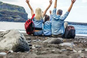 glücklich Familie Stehen auf das Strand auf das Dämmerung Zeit foto