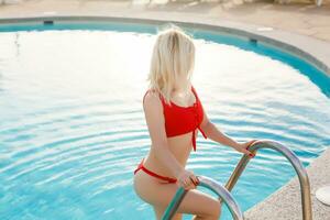 ein jung schön Frau entspannt sich beim das Schwimmen Schwimmbad. Wellness Konzept. Spa und entspannen, Frau Glück. getönt Bild foto