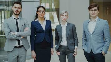 Porträt von Gruppe von Geschäft Menschen lächelnd im modern Büro drinnen. Mannschaft von Geschäftsleute und Geschäftsfrau Stehen zusammen foto