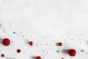 Weihnachten Komposition. Tanne Baum Geäst, rot Dekorationen auf grau Hintergrund, Blumen Komposition. Weiß und lila Blumen auf Marmor Hintergrund, Eukalyptus Blätter, Winter, oben Sicht. Weihnachten Geschenk. foto