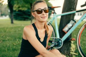 Mädchen lächelnd neben ihr Fahrrad im das Park foto