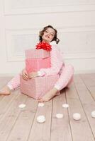 süß wenig Mädchen im Schlafanzug mit Süßigkeiten Sitzung auf das Fußboden foto
