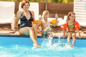 Mutter und Kinder im das Schwimmbad foto