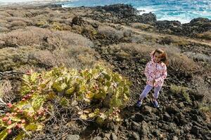 wenig Mädchen steht in der Nähe von ein Kaktus auf das Insel von Tenerife foto