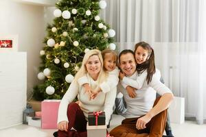 glücklich Familie Vater Mutter und Kinder Sitzung durch Kamin auf Weihnachten Vorabend foto