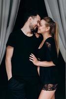 glückliches Paar erwartet Baby posiert auf dunklem Hintergrund, Profil