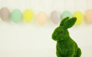 Grün Ostern Hase auf ein Hintergrund von Girlanden von dekorativ Eier. foto