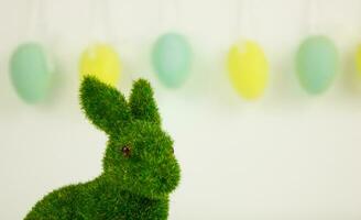 Grün Ostern Hase auf ein Hintergrund von Girlanden von dekorativ Eier. foto