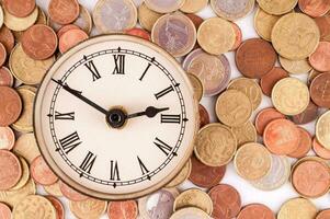 ein Uhr ist umgeben durch Münzen foto