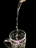 ästhetisch Foto von Gießen Wasser in ein Glas mit schwarz Hintergrund