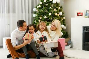 glücklich Familie Vater Mutter und Kinder Sitzung durch Kamin auf Weihnachten Vorabend foto