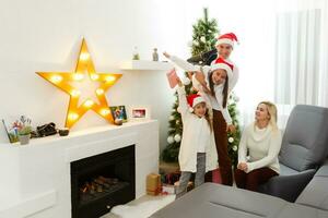 glücklich Familie Vater Mutter und Kinder Sitzung durch Kamin auf Weihnachten Vorabend foto