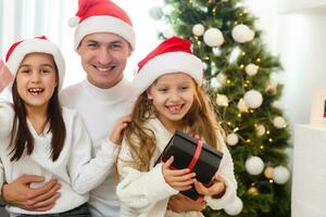 glücklich Familie Vater Mutter und Kinder Sitzung durch Kamin auf Weihnachten Vorabend foto