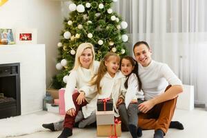 glücklich Familie Vater Mutter und Kinder Sitzung durch Kamin auf Weihnachten Vorabend foto