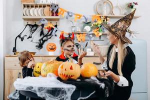 Mutter und Kinder unterhalten sich und haben eine lustige Zeit zu Hause. -Halloween-Konzept foto