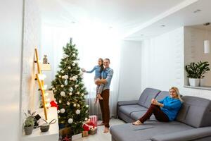 jung Familie auf Weihnachten Morgen austauschen die Geschenke und genießen ihr Zeit zusammen. foto