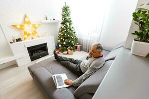 alt Alter, Feiertage, Problem und Menschen Konzept - - Senior Mann im Brille Denken beim Zuhause Über Weihnachten Baum Hintergrund foto