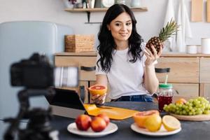 süße, attraktive Frau, die über gesunde Ernährung spricht und Videos macht foto