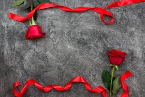 Valentinstag oder andere Liebesferien. auf grauem Hintergrund sind rote Trojaner mit rotem Band verziert, Draufsicht