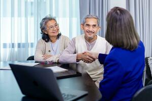 asiatisch Senior Paar Händeschütteln das Anwalt nach Fertig das finanziell Vertrag und Versicherung Gesundheit Pflege Vorteil zum Pensionierung Zuhause Besuch Bedienung durch Fachmann Berater foto