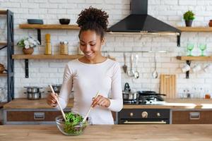 hübscher Haushalt, der zu Hause ein gesundes Essen kocht - Salat - Bild foto