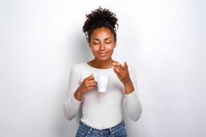 erfreutes süßes Mulattin-Mädchen atmet das Aroma von Kaffee ein foto