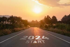 glücklich Neu Jahr 2024,2024 symbolisiert das Start von das Neu Jahr. das Brief Start Neu Jahr 2024 auf das Straße im das Natur Route Fahrbahn Sonnenuntergang Baum Umgebung Ökologie oder Grün Hintergrund Konzept. foto