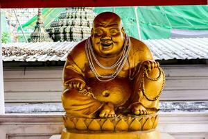 ein Statue von ein Lachen Buddha im ein Tempel foto