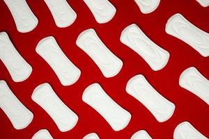 hygienische weibliche Pads auf rotem Hintergrund, Menstruation. foto
