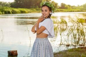 jung schön kaukasisch Frau Stehen beim das Bank von Fluss. traditionell Landschaft Bild mit Mädchen beim Vordergrund und Kopieren Raum. foto