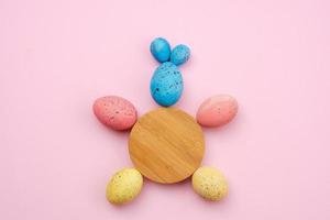 Nahaufnahme eines Kaninchens aus Eiern und einem Holzkreis auf dem Tisch. Ostern-Konzept foto
