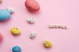 Frohe Ostern-Konzept. Bunte Eier sind auf einem süßen, rosa Hintergrund ausgelegt. foto