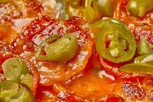 Nahansicht von Peperoni Pizza mit eingelegt Jalapenos, Käse und Tomate Soße foto