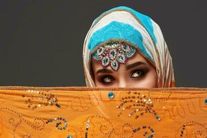 Studio Schuss von ein verschönern weiblich tragen das bunt Hijab dekoriert mit Pailletten und Schmuck. Arabisch Stil. foto