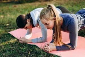 Foto von zwei entzückenden Mädchen, die draußen Übungen machen. Sportgurt