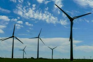 ein Gruppe von Wind Turbinen im ein Feld foto