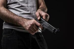 Mörder mit Gewehr auf schwarz Hintergrund beim das Studio foto