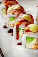 Sushi Rollen mit Sahne Käse, Avocado, Tobiko, Butterfisch, Mayonnaise und unagi Soße foto