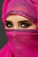 Nahansicht Schuss von ein jung charmant Frau tragen das Rosa Hijab dekoriert mit Pailletten. Arabisch Stil. foto