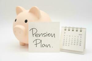 Schweinchen Bank, Schreibtisch Kalender und die Pension planen Hinweis Papier isoliert auf Weiß Hintergrund. zum Ruhestand, die Pension planen Konzept. zuletzt Datum von arbeiten. foto