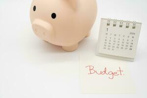 Budget Text auf Papier, Schweinchen Bank mit 2024 jan Kalender auf ein Weiß Hintergrund. Finanzen, Geld Verwaltung Konzept. foto