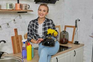 inländisch Bedienung und Hauswirtschaft Konzept, glücklich blond Dame Reinigung Küche Wasserkocher. foto