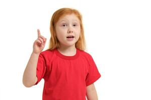 Porträt von süß Rothaarige emotional wenig Mädchen mit Finger oben isoliert auf ein Weiß foto