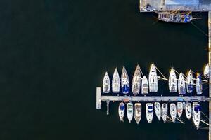 Antenne Aussicht durch Drohne von Yachten und klein Motor- Boote. Weiß Boote im Meer Wasser. Yacht und Segelboot sind festgemacht beim das Kai. Parkplatz foto