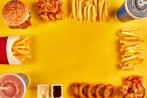oben Aussicht Hamburger, Französisch Fritten und gebraten Hähnchen auf Gelb Hintergrund. Kopieren Raum zum Ihre Text. foto