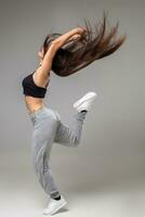 modern Tänzer posiert im Vorderseite von das grau Studio Hintergrund foto