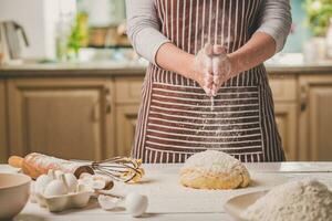 Frau schlagen seine Hände über Teig Nahaufnahme. Bäcker Fertigstellung seine Bäckerei, Shake Mehl von seine Hände, kostenlos Raum zum Text. foto