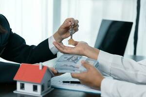 Immobilienmakler, der dem Kunden nach Unterzeichnung des Vertrages Hausschlüssel übergibt Vertrag Immobilien mit genehmigtem Hypothekenantragsformular, betreffend Hypothekendarlehensangebot für und Hausversicherung. foto